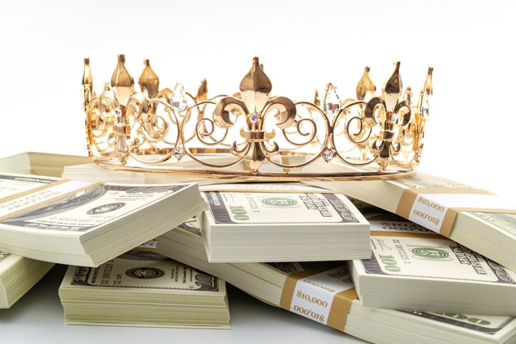 A pile of paper money with crown on top.